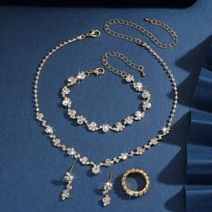 Dettaglio di un set di gioielli dorati con collana, bracciale, orecchini e anello con zirconi
