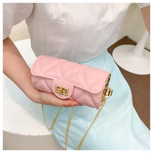 Close-up of pink quilted cylinder bag with glossy finish and gold chain strap detail