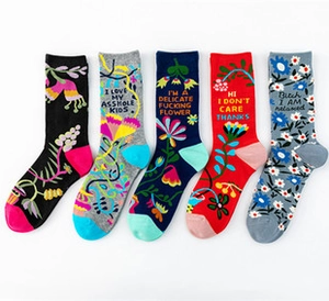 Detail of five cotton socks featuring colorful floral patterns and humorous English slogans