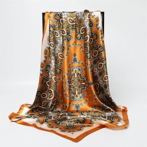 Vue détaillée d'un foulard en satin aux motifs Paisley orange et blanc élégants