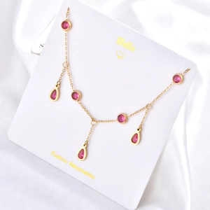 Collier élégant en or avec zircons rouges sur une carte de présentation en soie blanche
