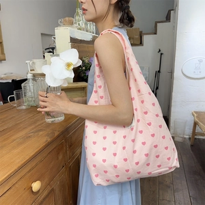 Detail of pink heart canvas tote bag with wide strap for casual daily commuting