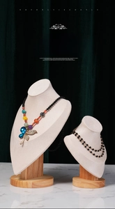 Detail of colorful beaded butterfly pendant necklace on a cream velvet jewelry display