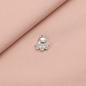 Detailed view of silver octopus charm pendant for DIY jewelry on pink fabric