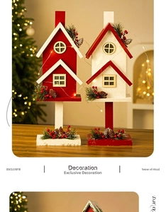 Dettaglio di casette di Natale in legno con pigne, bacche rosse e luci a LED integrate