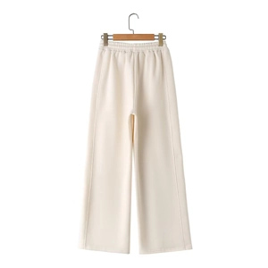 Detail of off-white wide-leg knitted trousers with elastic waistband and decorative stitching