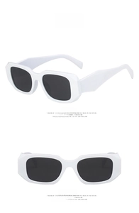 Close-up of stylish white rectangular sunglasses with dark grey lenses and geometric arms