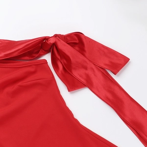 Détail de la robe en satin rouge avec un nœud élégant et une texture de tissu soyeuse