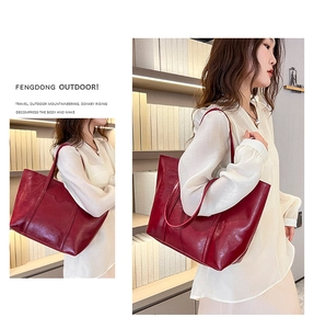 Glossy red faux leather tote bag with large capacity and shoulder strap detail