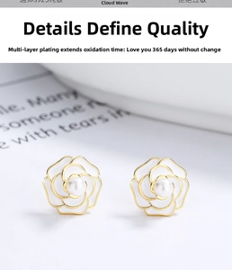 Detailed close-up of 925 silver camellia earrings with white enamel and a pearl center