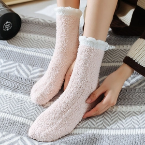 Close-up of fluffy pink coral fleece thermal socks with white plush cuff and soft texture