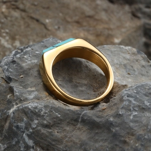 Macro detail of men's gold stainless steel ring with rectangular turquoise stone inlay