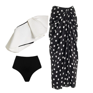 Three-piece bikini set with white ruffle top, black bottoms, and polka dot wrap skirt