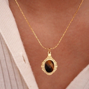French vintage style tiger eye stone necklace with gold hollow frame worn by model