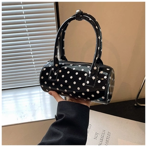 Detail of glossy polka dot Boston bag showing premium shiny leather and metal zipper