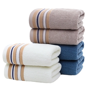Three-color set of soft cotton towels with striped edges in blue, white, and beige tones
