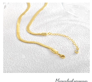Detailed view of gold snake chain choker with lobster clasp and micro-inlaid zircon drop