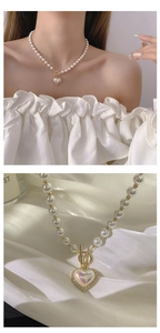 Macro detail of heart pendant pearl necklace with sparkling crystals and gold toggle clasp