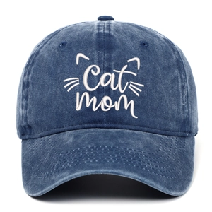 Close-up of white Cat Mom embroidery and whisker details on navy blue washed denim cap
