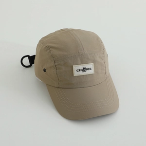 Close-up of quick-dry khaki camp cap featuring black CHANGE label and D-ring strap