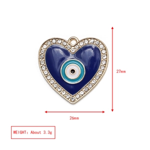 Detailed view of heart-shaped evil eye pendant with blue enamel and crystal inlay