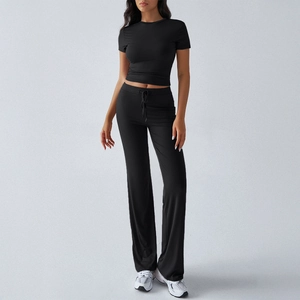 Women's two-piece black lounge set featuring a short sleeve crop top and drawstring pants