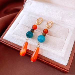 Detailed shot of ethnic agate earrings with teardrop pendants and colorful beads