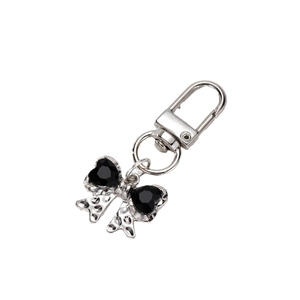 Silver bow keychain with black heart gemstone and crystal accents on white background