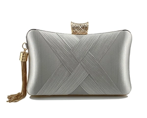 Close-up of woven silver evening bag featuring crystal clasp and gold metal tassels