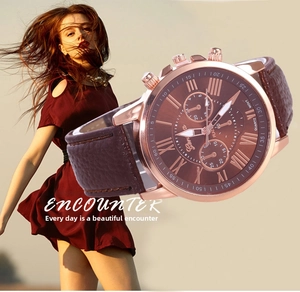 Detail of rose gold Geneva watch with Roman numeral dial and dark brown leather strap