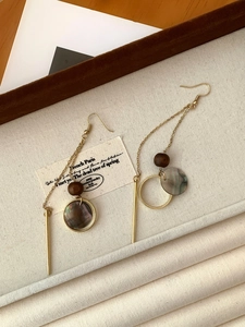 Detail of vintage long drop earrings with dark wood beads and iridescent shell pendants