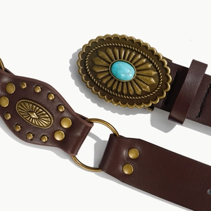 Dettaglio cintura vintage in pelle marrone con fibbia in metallo e pietra turchese