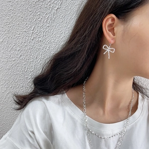 925 silver bow earrings with zircon stones and layered necklace worn by a model