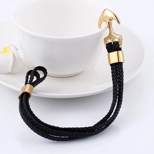 Detail of men's black braided leather anchor bracelet hooked on a white ceramic cup