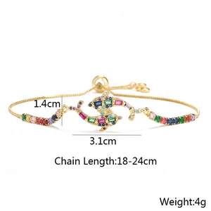 Detailed view of dual dolphin gold bracelet with colorful cubic zirconia and dimensions