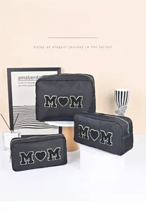 Gedetailleerde set van drie zwarte chenille make-up tassen met gouden MOM-patch