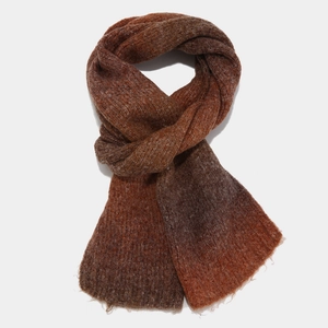 Close-up of tie-dye knit scarf featuring coffee and rust red gradient colors and soft textures