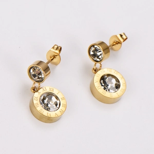 Macro shot of gold-plated drop earrings with Roman numerals and sparkling zircon stones