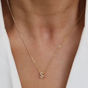 Elegant 18k gold initial S necklace with micro-paved zircons worn on model neck