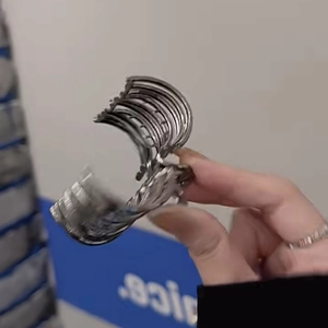 Silver wide cuff bracelet with horizontal ribbed texture shown in a hand-held view