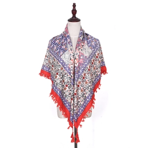 Detail of bohemian floral square scarf with red tassels and intricate jacquard pattern