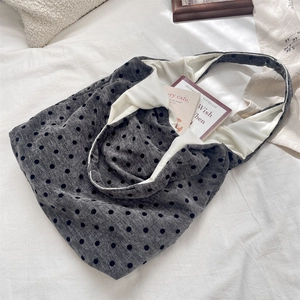 Close-up of gray polka dot canvas tote bag with white lining in a lifestyle setting