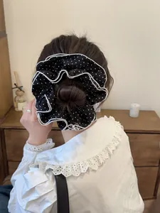 Polka dot oversized hair scrunchie with pleated layers shown on an elegant bun hairstyle
