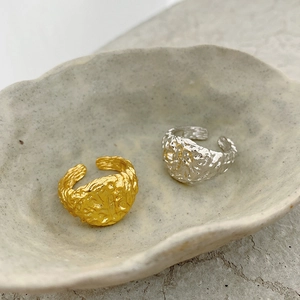 Detail of irregular lava texture on gold and silver S925 sterling silver open rings