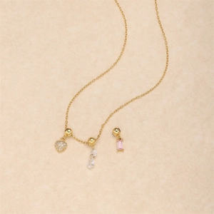Detail of gold chain necklace with heart pendant and pink cubic zirconia drop charms