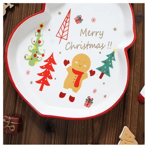 Detail of hand-painted ceramic Christmas plate featuring a gingerbread man and tree