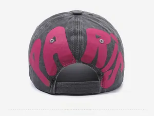 Detail view of the back of a washed gray baseball cap featuring a pink PARIS printed logo