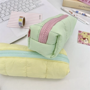 Quilted down-textured pencil cases in mint green and pale yellow with pastel zippers