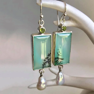 Vintage geometric drop earrings featuring green stones and baroque pearls on hand model