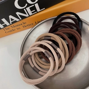 Vue à plat de plusieurs élastiques à cheveux extensibles aux tons terreux sur plateau